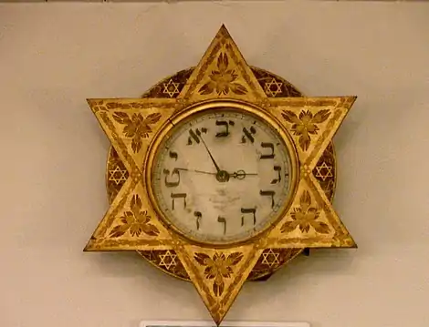 Reloj de la Sinagoga de Ámsterdam, siglo XVIII. En vez de números romanos o arábigos, emplea caracteres hebreos en concordancia con su valor numérico.