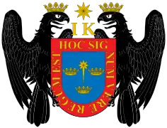 Escudo de armas de Lima con los símbolos de los descendientes de los reyes católicos, Juana y Carlos, iniciales I y K, y dos águilas de San Juan.