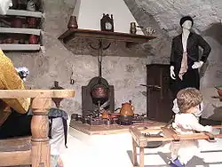 Reproducción de una cocina tradicional en el Museo de Teruel; a la izquierda, un vasar en alto con cacharrería alfarera popular.