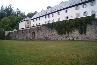 Muro de la Caridad (derecha) donde se observa el vano de la puerta en el centro y cuatro hiladas a cada lado donde se apoyaron los arcos transversales de piedra.