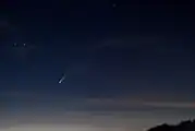 Cometa Neowise al tardecer visto desde España con algunas nubes en color rojo.