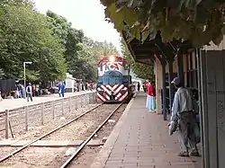 Tren de cargas transportando bobinas de acero pasando por la estación.