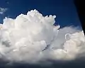 Nube cumulonimbus, al lado de un vórtice de herradura