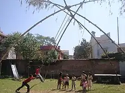 Niños jugando en columpios de bambú tradicionales