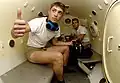 Two United States Navy sailors inside a decompression chamber about to undergo training