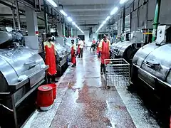 Calcetines de máquina en la planta de lavado de tintura para fregar los pantalones vaqueros.