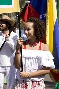 Una mujer sonriente sosteniendo una pancarta