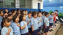 Niños indígenas cantando el himno nacional