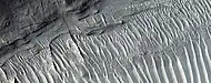 Vista cercana de las capas, como las ve HiRISE en el programa HiWish Una cresta atraviesa las capas en ángulo recto.