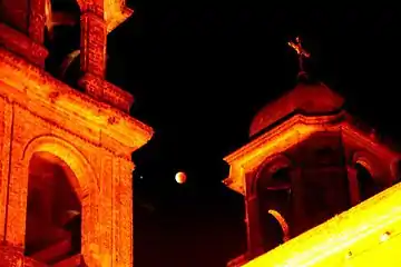 Fotos tomadas desde el centro de la ciudad de Dolores, Uruguay, se ve la luna roja, entre las dos torres de la iglesia.