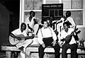 Régulo Ramírez ensayando un número con un grupo musical nativo de San Andrés, durante el rodaje de Isla de Ensueño. Al fondo se ve el tablero de instrucciones diarias de la Productora.