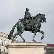 Estatua ecuestre de Carlos III, resultado de distintos proyectos (Manuel Francisco Álvarez de la Peña y Juan Pascual de Mena). Hay una estatua ecuestre anterior del mismo Carlos, como rey de Nápoles, por Antonio Canova, que comparte la Piazza del Plebiscito con otra de Fernando II, de Antonio Calì.