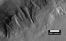 Proceso geológico denomiado derrubios frontales lobulados. Las rayas indican movimiento. Imagen ubicada en el cuadrilátero de Ismenius Lacus. Se ha demostrado que los derrubios frontales lobulados contienen hielo de agua casi pura cubierta con una capa de escombros rocosos