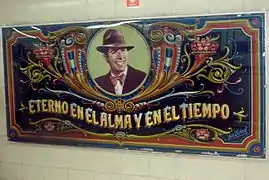 Retrato de Carlos Gardel frente a la boletería de la estación, obra del fileteador León Untroib.