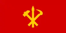 Bandera del Partido del Trabajo de Corea: útiles proletarios cruzados (hoz y martillo) con un pincel de caligrafía coreana que representa la intelligentsia