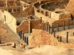 Vista detallada del foro triangular, con el propíleo en primer plano y parte de los dos pórticos longitudinales. Detrás se aprecian la palestra samnita y el teatro grande. Maqueta expuesta en el Museo Arqueológico Nacional de Nápoles.