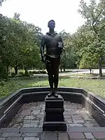 Broze statue of a young boy holding books