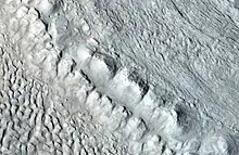 Ampliación del área en rectángulo de la imagen anterior. En la Tierra, la cresta se llamaría la morrena terminal de un glaciar alpino. Fotografía tomada por HiRISE y su programa HiWish