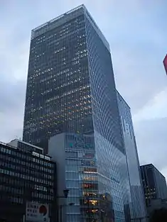 Ground-level view of a glass, rectangular high-rise