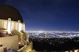 Vista nocturna de la cúpula del observatorio con la Ciudad de Los Ángeles de fondo.