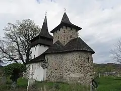 Iglesia Arcángel San Miguel en Gurasada, en la que el cuerpo de la entrada, en blanco, ha sustituido al cuarto ábside