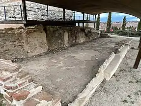 Habitación de la zona este, de forma rectangular cuyo uso se relaciona con las labores de cocina. El espacio cuenta con un pozo a ras del suelo y en su momento hubo un espacio usado como hogar y espacio de almacenaje.