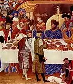 Les Très Riches Heures du duc de Berry, enero (detalle), c. 1410; los dos cortesanos de pie detrás de la mesa a la izquierda visten chaperones de confección elaborada.