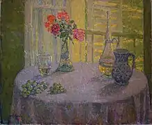 Jarrón de flores junto a una ventana