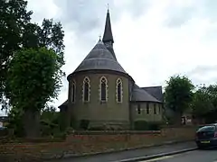 Iglesia de la Santísima Trinidad (1865) Lyonsdown Road, New Barnet, Londres, mostrando el fuerte ábside del presbiterio en stock brick con bandas de ladrillo rojas