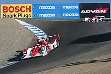 Dos sport prototipos negociando el sacacorchos de Laguna Seca en una carrera de la American Le Mans Series en 2006.