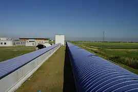 Vista del brazo oeste de 3 km de longitud de Virgo (tubo derecho). El tubo de la izquierda, de 150 m de longitud, alberga la cavidad del limpiador de modos que se utiliza para filtrar espacialmente el rayo láser.