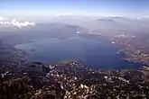 Lago de Ilopango, visto desde el este. Se puede ver San Salvador y el Volcán de San Salvador atrás del lago.