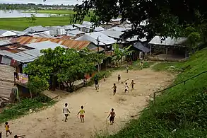 Niños jugando fútbol en el barrio de Belén, atrás se ve a la bahía.