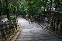 Camino de acceso al santuario guardado por filas de linternas de piedra.