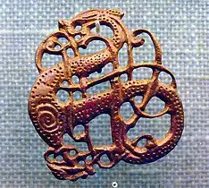 Filigrana vikinga en bronce del siglo XI. La principal aportación de la influencia bárbara al arte altomedieval fue su particular enfoque del problema de la ornamentación, que dejó de ser naturalista para pasar a ser muy geométrica, casi heráldica; motivos trenzados y "en tenaza", la geometrización de motivos anteriores, como las vides pobladas de aves o la misma cruz, desde la cristianización de los bárbaros fueron interpretados de forma totalmente innovadora.