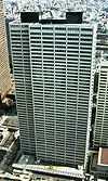 Aerial view of a white, rectangular high-rise lined with rows of windows