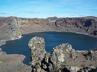 Un lago azul dentro de una depresión similar a un cráter en el paisaje