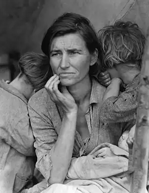 Mujer y sus dos niños vestidos con ropa gastada y monótona. California en 1936.