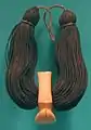 Lei niho palaoa (colgante hawaiano), s. XIX, diente de cachalote tallado, cabello humano trenzado, cordón de olonā, Honolulu Museum of Art