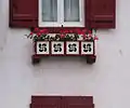 Ventana con lauburu en Hasparren, Labort.