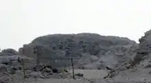 Low ruins of a pyramid in the desert.