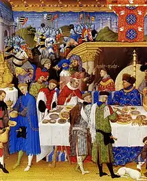 Ilustrando el calendario de Enero de Las muy ricas horas del duque de Berry (hermanos Limbourg, 1411-1416), se retrata al comitente en una escena profana, invitando a su mesa a sus allegados. Las paredes de la estancia están cubiertas de tapices que representan la Guerra de Troya.