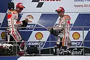 Marc Márquez y Dani Pedrosa celebran con champán la victoria en el Gran Premio de Malasia de Motociclismo de 2013.