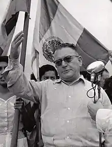 Fotografía de Miguel Henríquez Guzmán, candidato del Partido Constitucionalista Mexicano en 1952. Nótese al fondo la bandera con el sello en vez del escudo.