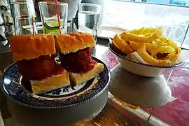 Un sándwich de albóndigas con aros de cebolla en un restaurante de Londres