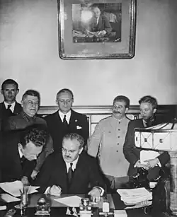 El ministro de Asuntos Exteriores soviético Vyacheslav Molotov firma el Pacto Molotov-Ribbentrop. Detrás de él, el ministro de Asuntos Exteriores alemán Joachim von Ribbentrop y el primer ministro soviético Joseph Stalin