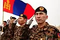 Soldados mongoles saludando mientras ondea la bandera mongola en el Centro de Tránsito de Manas, donde permanecieron durante varios días antes de avanzar hacia Afganistán para apoyar la Operación Libertad Duradera.