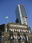 La bandera de Róterdam con el logo de Holland America Line en un edificio de la empresa.