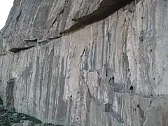 Foto del monte Behistún. Tome en cuenta el tamaño de los escaladores a comparación al tamaño de la montaña