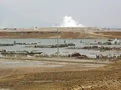 La imagen muestra la escala del pozo de barro, con esfuerzos para contenerlo quitando el lodo y creando terraplenes para la defensa contra inundaciones.